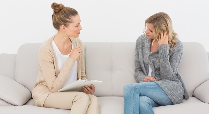 Upset woman talking to her therapist on the couch at therapy session Upset woman talking to her therapist on the couch at therapy session